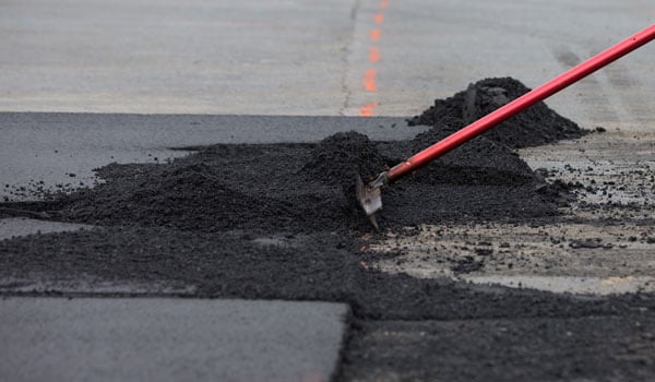 worker resurfacing asphalt